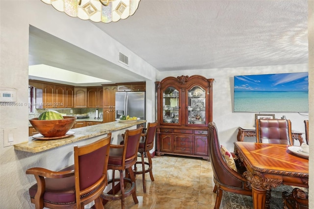 dining room with a textured ceiling and light tile patterned floors