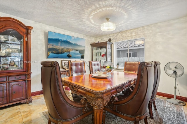 tiled dining space with a textured ceiling