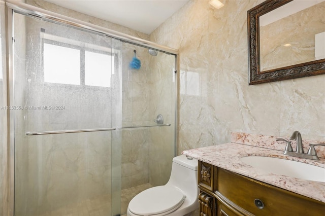 bathroom featuring tile walls, vanity, toilet, and an enclosed shower