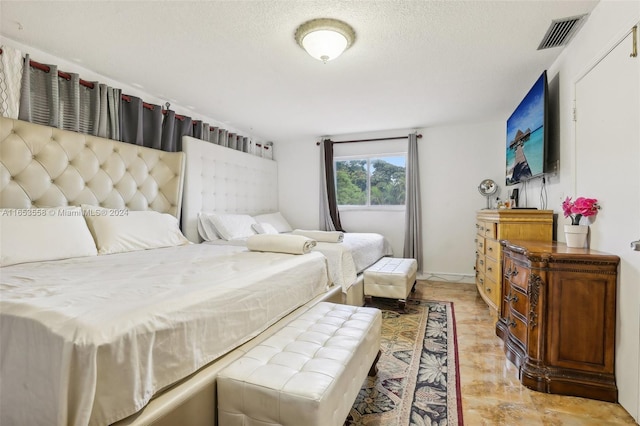 bedroom featuring a textured ceiling and light hardwood / wood-style floors