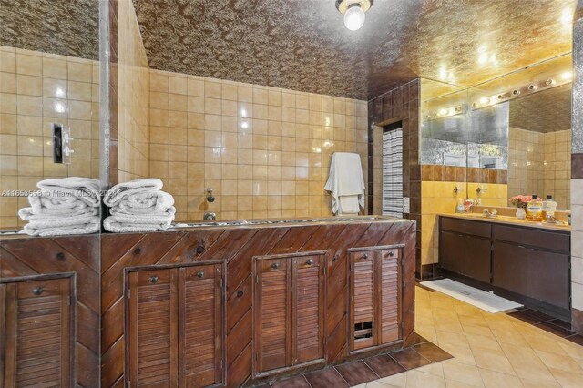 bathroom featuring tile walls, tile patterned floors, and vanity