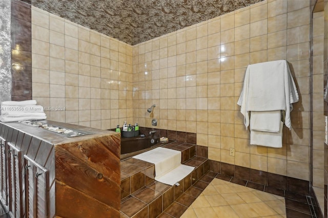 bathroom featuring tile walls, a washtub, and tile patterned floors