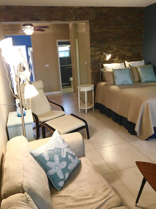 bedroom featuring light tile patterned floors, ceiling fan, and ensuite bath