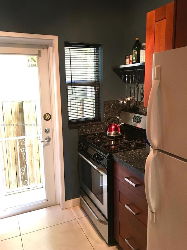 kitchen featuring gas range, plenty of natural light, and white fridge