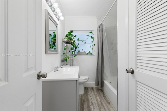 full bathroom with toilet, hardwood / wood-style flooring, shower / tub combo with curtain, and vanity