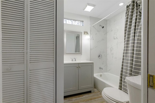 full bathroom featuring shower / bath combo, wood-type flooring, toilet, and vanity