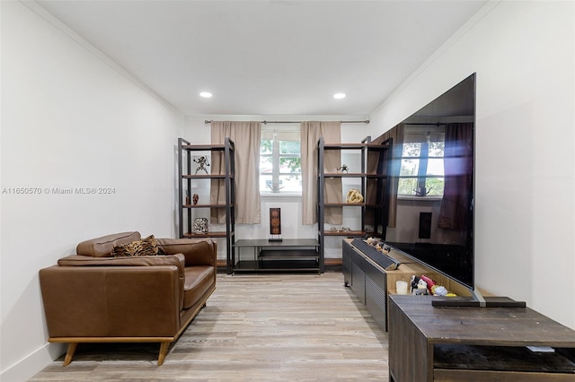 living room with crown molding and light hardwood / wood-style flooring