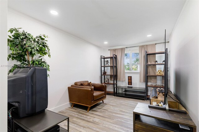 living room with light hardwood / wood-style flooring and ornamental molding