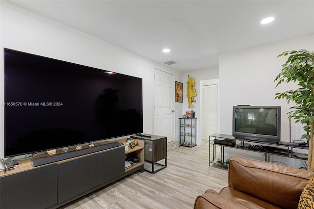 living room with ornamental molding and light hardwood / wood-style flooring