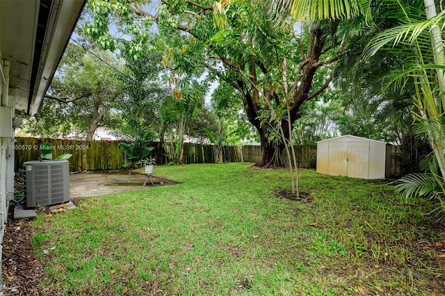 view of yard featuring central air condition unit, a storage unit, and a patio area