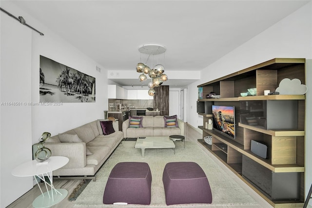 living room with light wood-type flooring and a chandelier