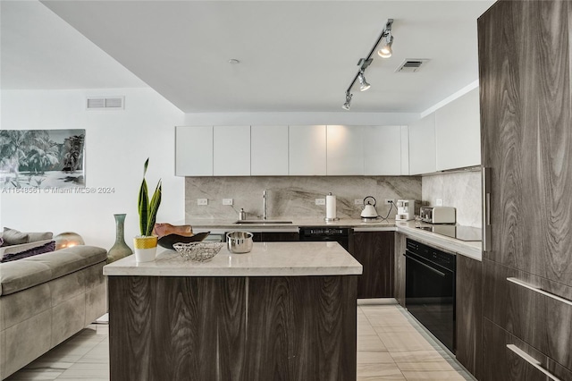 kitchen with a kitchen island, black appliances, tasteful backsplash, sink, and white cabinets