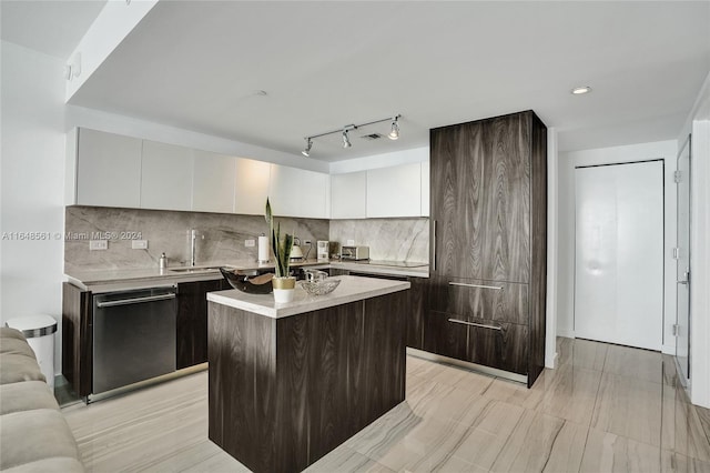 kitchen with track lighting, white cabinetry, a center island, decorative backsplash, and stainless steel dishwasher