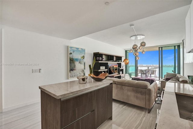 living room featuring light wood-type flooring, expansive windows, and an inviting chandelier