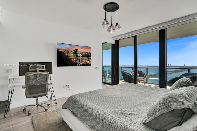 bedroom with access to exterior, a notable chandelier, expansive windows, and multiple windows