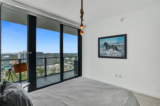 bedroom with wood-type flooring and access to exterior