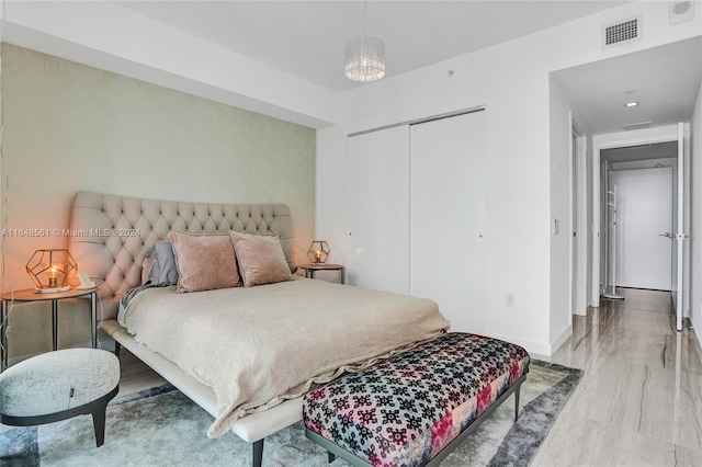 bedroom with an inviting chandelier and a closet