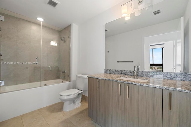 full bathroom featuring shower / bath combination with glass door, tile patterned flooring, toilet, and vanity