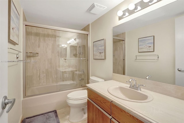 full bathroom featuring shower / bath combination with glass door, vanity, toilet, and tile patterned flooring