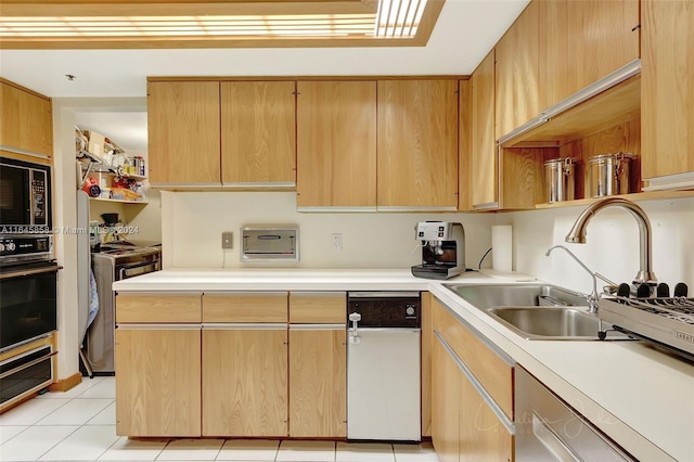 kitchen featuring black appliances, light brown cabinets, light tile patterned floors, and sink