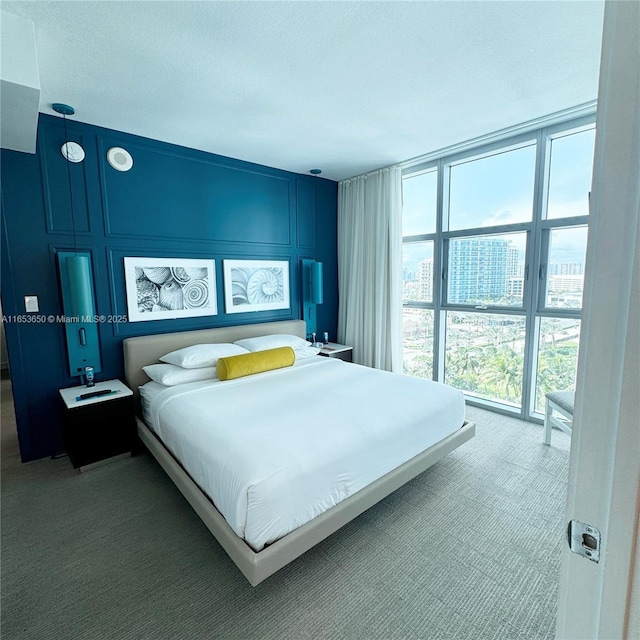 carpeted bedroom featuring a wall of windows