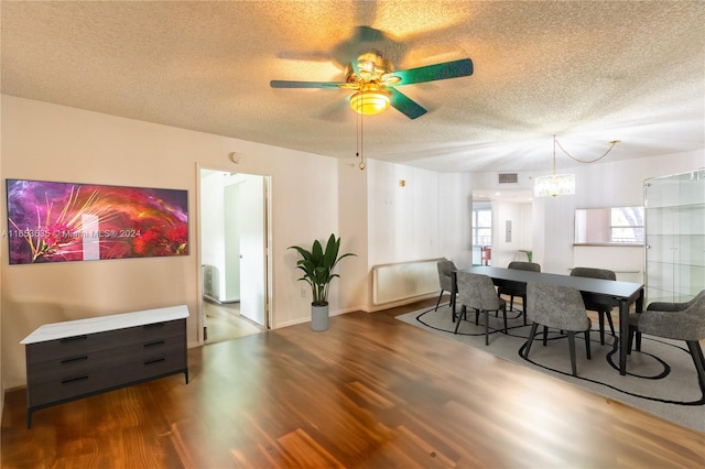 dining space featuring hardwood / wood-style floors, ceiling fan with notable chandelier, and a textured ceiling