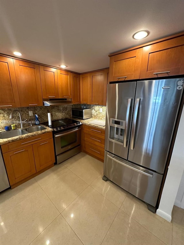 kitchen with sink, light tile patterned floors, appliances with stainless steel finishes, and decorative backsplash