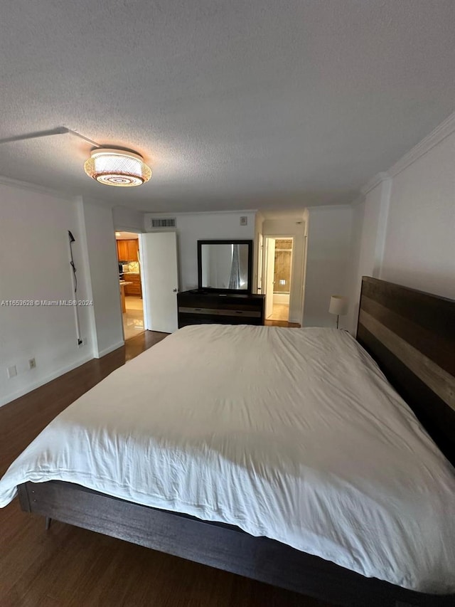 bedroom featuring a textured ceiling and dark hardwood / wood-style floors