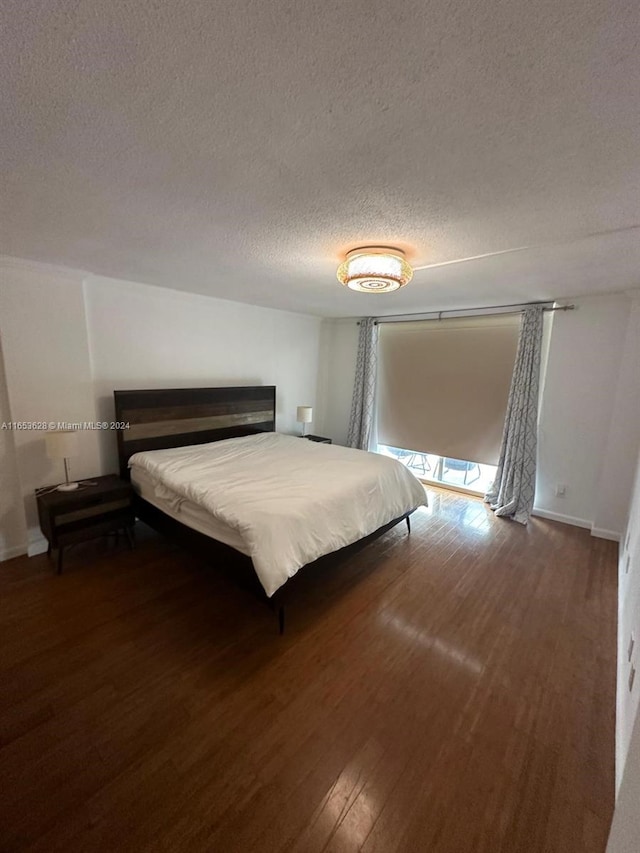 unfurnished bedroom featuring a textured ceiling and dark hardwood / wood-style flooring