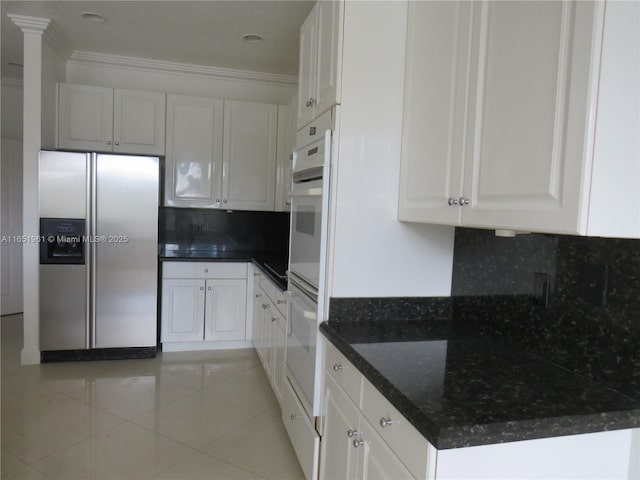 kitchen with light tile patterned floors, tasteful backsplash, stainless steel refrigerator with ice dispenser, and white cabinetry