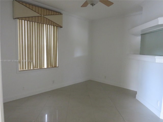 empty room featuring tile patterned flooring, baseboards, crown molding, and ceiling fan