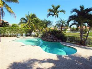 pool with fence and a patio area