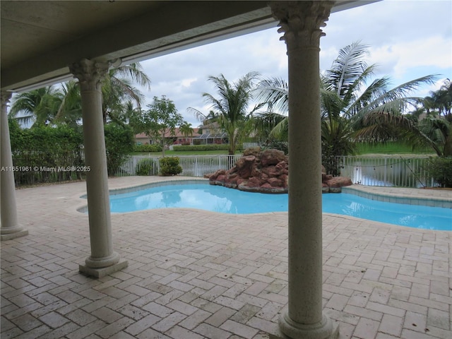 view of pool with a fenced in pool, a patio, a water view, and fence