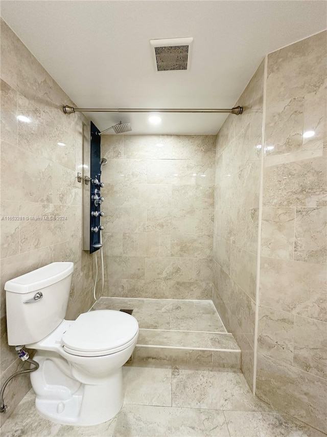 bathroom with toilet and a tile shower