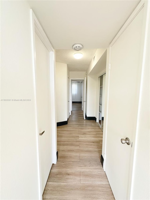 corridor with light hardwood / wood-style floors