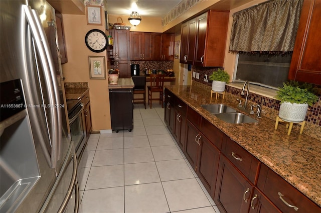 kitchen with light stone countertops, tasteful backsplash, sink, light tile patterned floors, and stainless steel fridge with ice dispenser