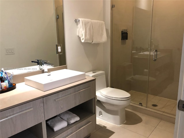 bathroom with tile patterned flooring, vanity, toilet, and an enclosed shower