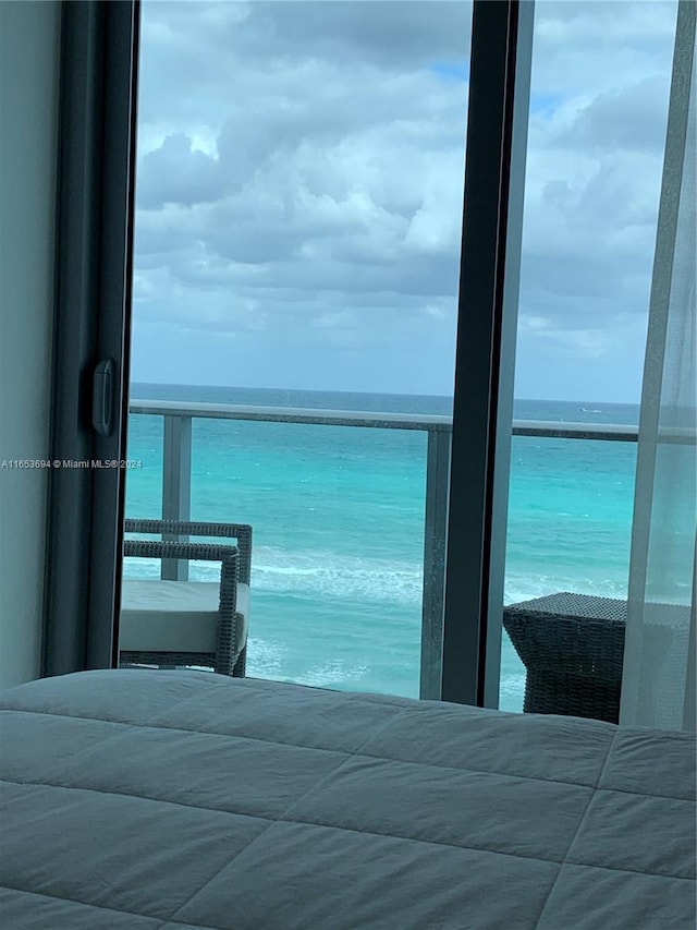 bedroom featuring a beach view and a water view