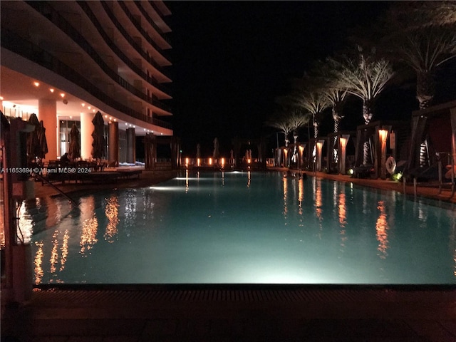 view of pool at twilight