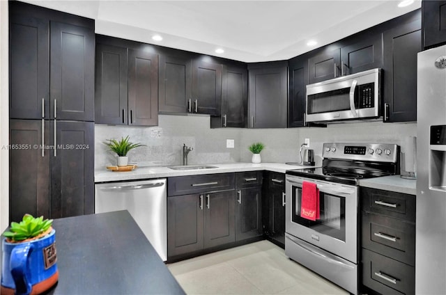 kitchen with light tile patterned floors, stainless steel appliances, tasteful backsplash, and sink