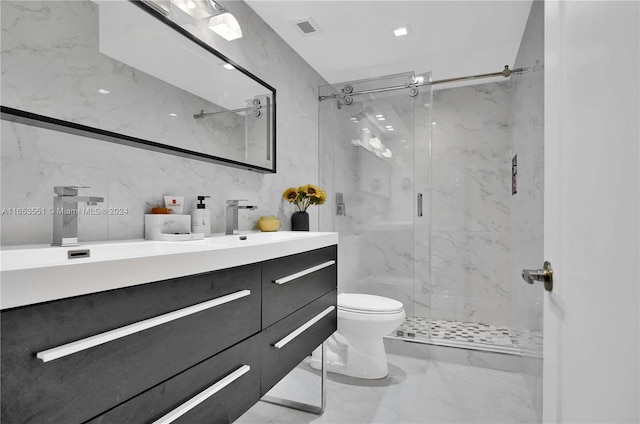 bathroom featuring tile walls, vanity, a shower with shower door, and toilet