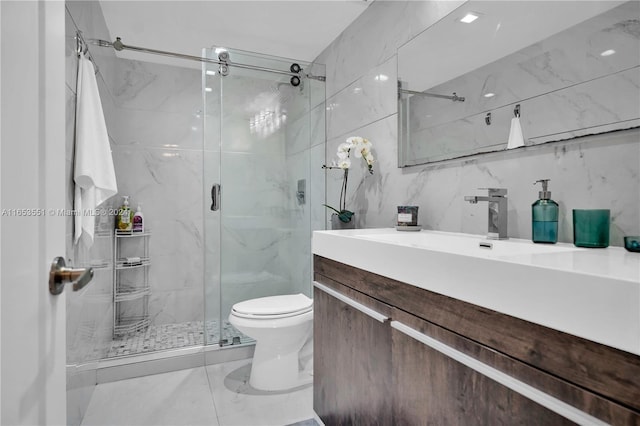 bathroom featuring vanity, toilet, tile walls, and a shower with shower door