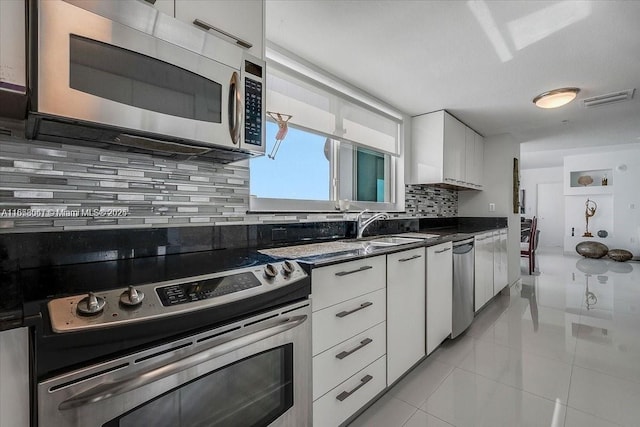 kitchen featuring white cabinets, backsplash, stainless steel appliances, and sink