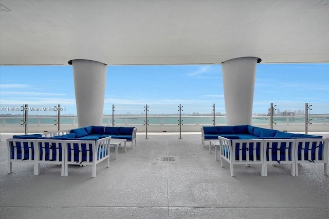 view of patio / terrace with a view of the beach, an outdoor living space, and a water view