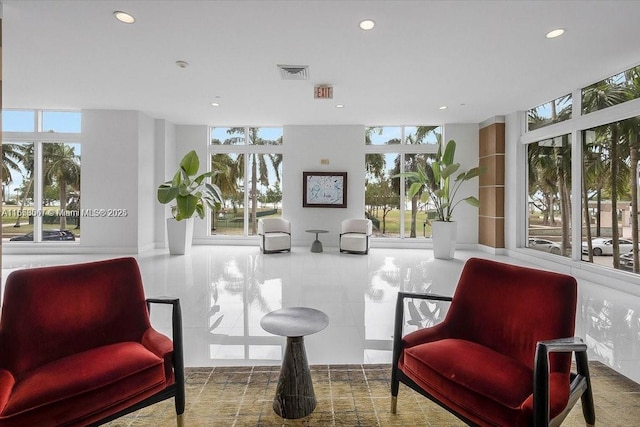 sitting room featuring tile patterned floors, floor to ceiling windows, and a healthy amount of sunlight