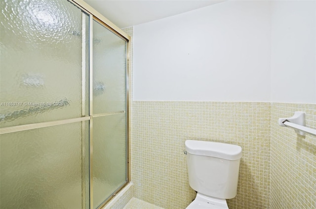 bathroom with toilet, tile walls, and walk in shower