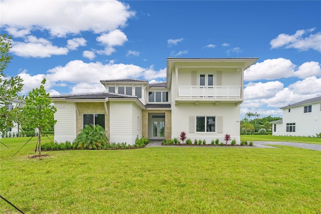 view of front facade featuring a front lawn and a balcony