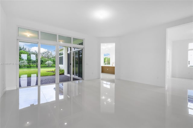 tiled empty room featuring a healthy amount of sunlight