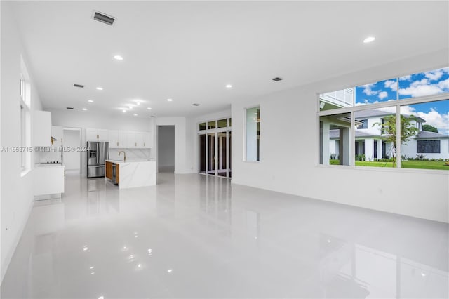 unfurnished living room featuring sink