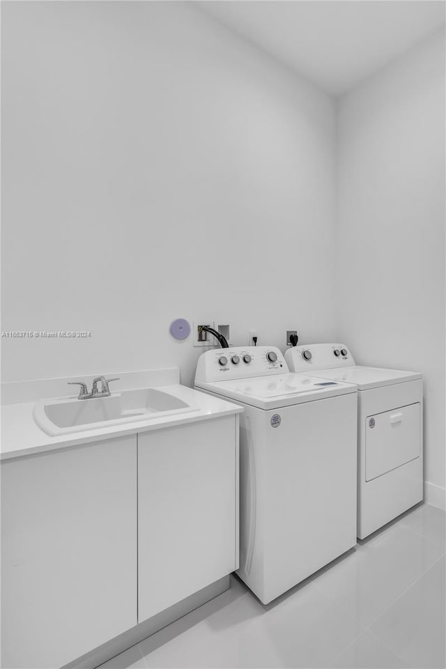 laundry area featuring sink, light tile patterned flooring, and separate washer and dryer